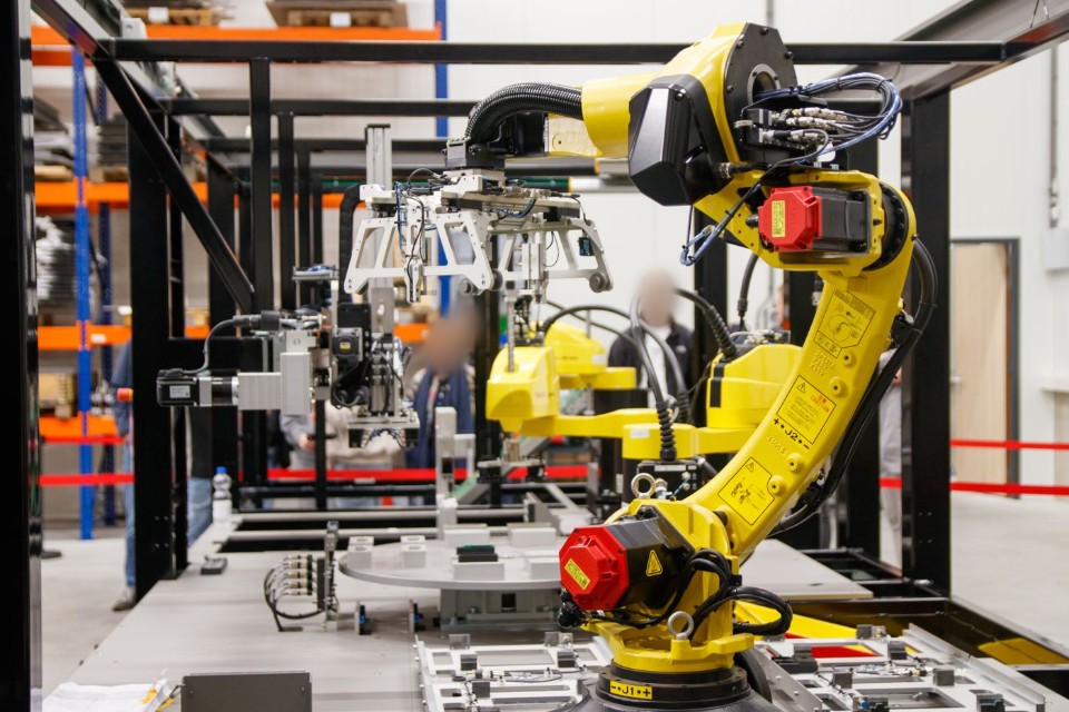Brazo robótico industrial amarillo en una línea de manufactura automatizada